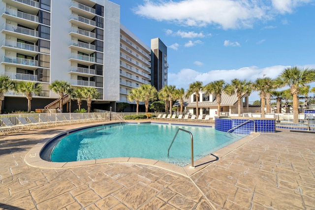 pool with a patio area and fence