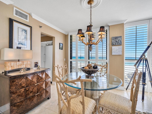 dining space with light tile patterned floors, a textured ceiling, visible vents, ornamental molding, and an inviting chandelier