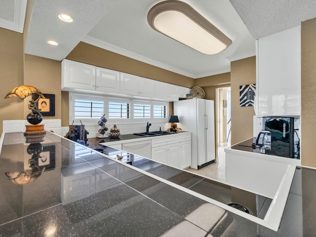 kitchen with crown molding, white appliances, white cabinetry, and a sink