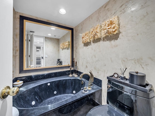 bathroom with visible vents and a tub with jets