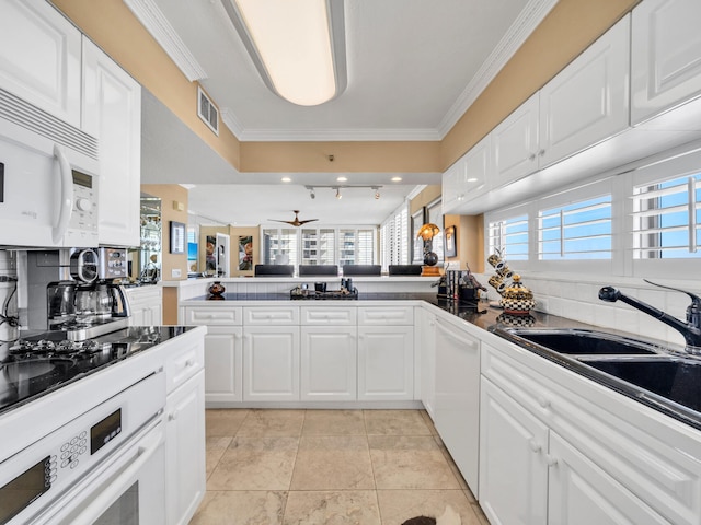 kitchen featuring visible vents, decorative backsplash, ornamental molding, a sink, and white appliances