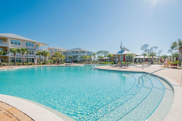 community pool with a residential view and a patio area