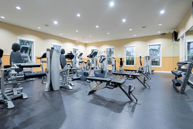 exercise room featuring a wainscoted wall, visible vents, and recessed lighting