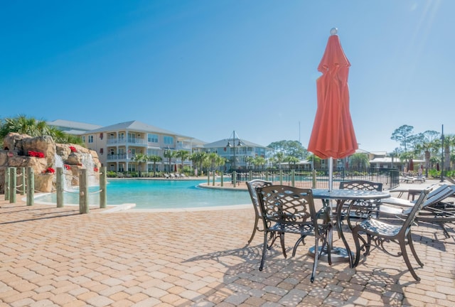 community pool with fence and a patio