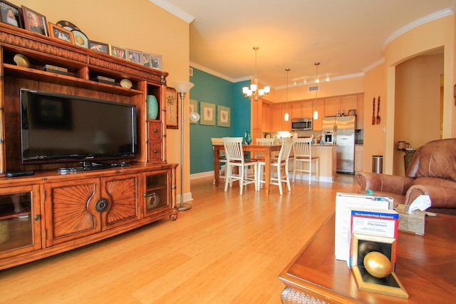 living area with crown molding, light wood finished floors, rail lighting, a chandelier, and baseboards