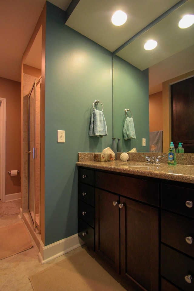 bathroom with baseboards, tile patterned floors, vanity, a shower stall, and recessed lighting