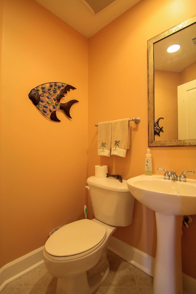 bathroom with toilet, visible vents, baseboards, and tile patterned floors