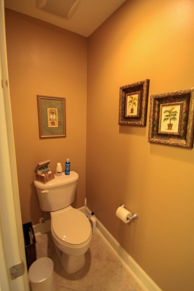 bathroom with baseboards, toilet, and tile patterned floors