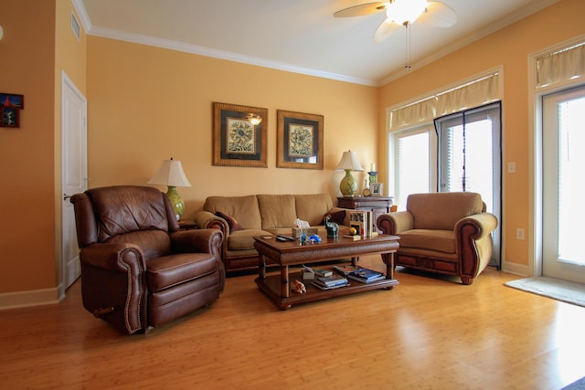 living area with visible vents, ornamental molding, ceiling fan, wood finished floors, and baseboards