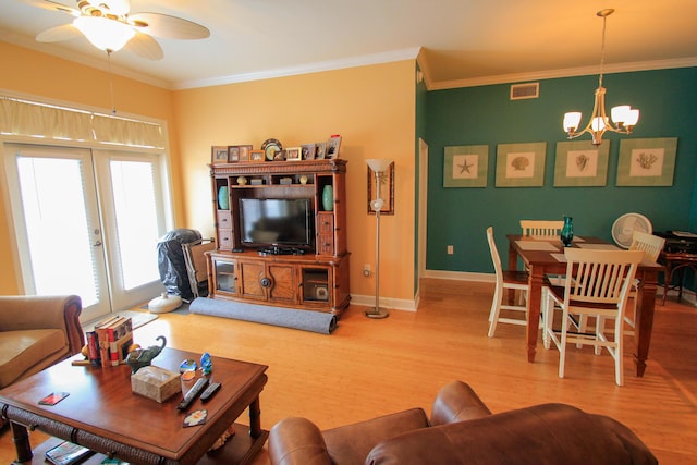 living area with french doors, wood finished floors, visible vents, and crown molding