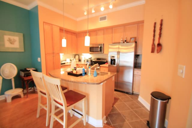 kitchen with a center island with sink, visible vents, stainless steel appliances, and crown molding