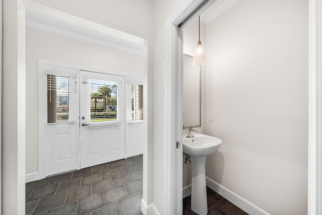 bathroom featuring a sink, baseboards, and ornamental molding