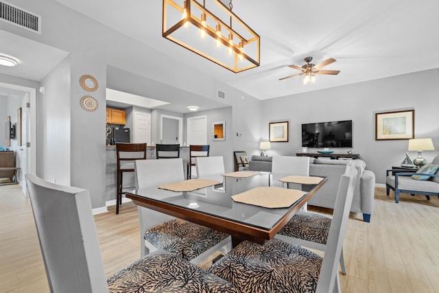 dining space with light wood-style floors, baseboards, visible vents, and ceiling fan