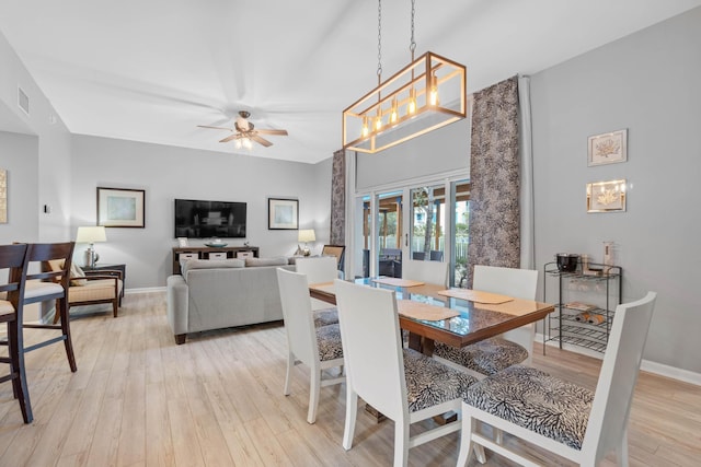 dining area featuring light wood finished floors, baseboards, visible vents, and ceiling fan with notable chandelier