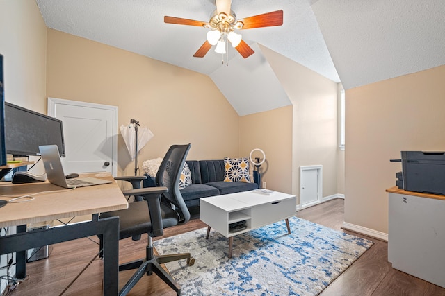 office space featuring lofted ceiling, ceiling fan, a textured ceiling, and wood finished floors