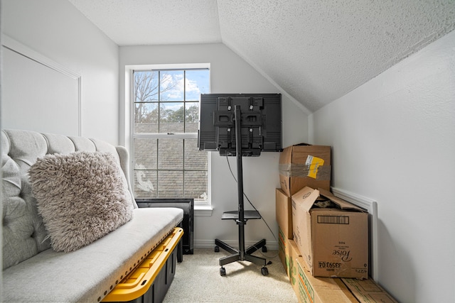 living area with lofted ceiling, light colored carpet, a textured ceiling, and baseboards