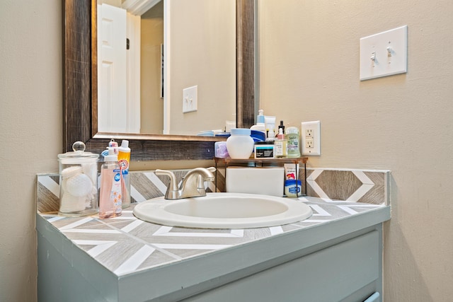 bathroom with a textured wall and vanity