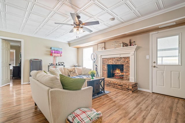 living area featuring an ornate ceiling, plenty of natural light, light wood finished floors, and baseboards