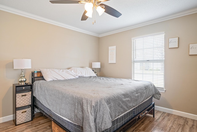 bedroom with ceiling fan, ornamental molding, wood finished floors, and baseboards