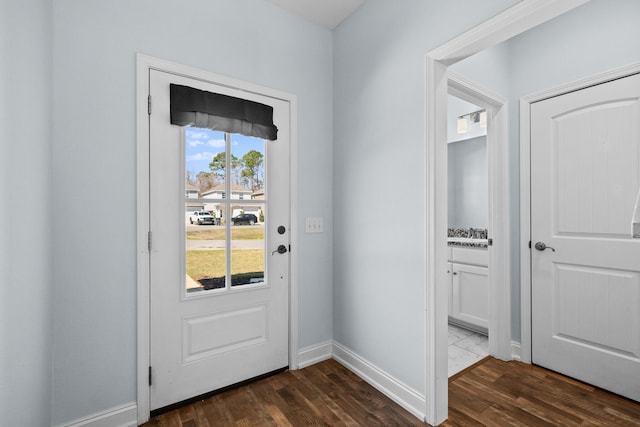 doorway to outside featuring dark wood finished floors and baseboards