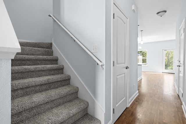 stairway with wood finished floors and baseboards