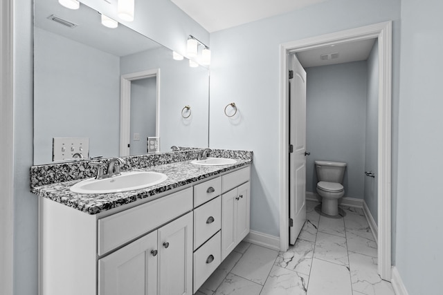 bathroom with toilet, marble finish floor, a sink, and visible vents