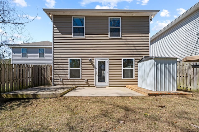 rear view of house featuring a fenced backyard, a storage unit, a lawn, and an outdoor structure