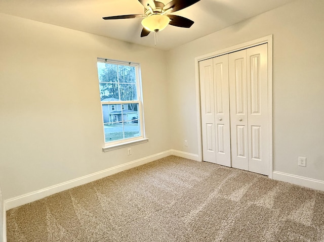 unfurnished bedroom with a closet, carpet flooring, a ceiling fan, and baseboards