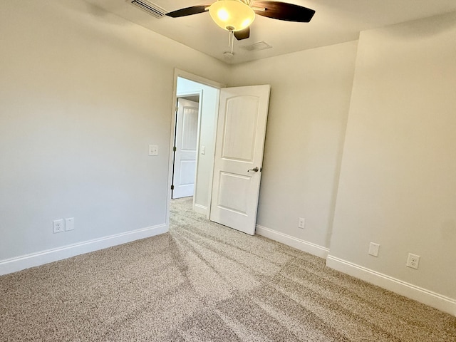 unfurnished room with baseboards, ceiling fan, visible vents, and light colored carpet