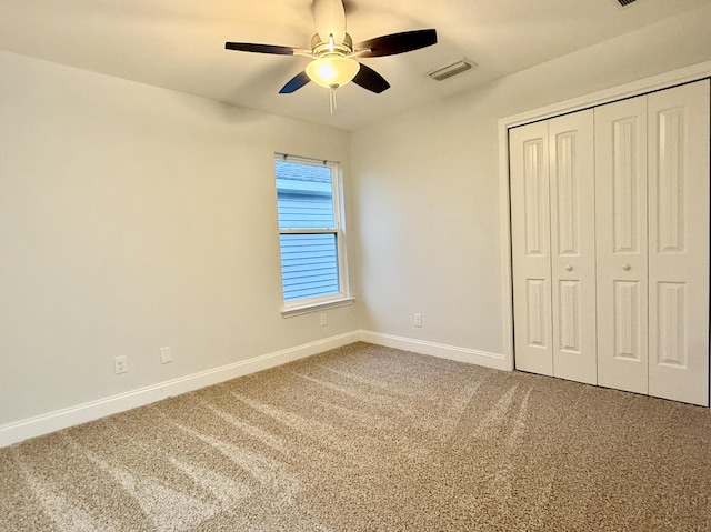 unfurnished bedroom with visible vents, baseboards, a ceiling fan, carpet floors, and a closet