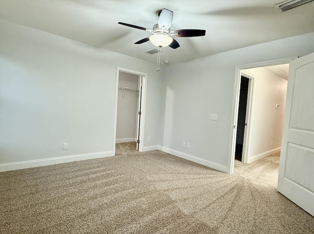 unfurnished bedroom featuring light carpet, visible vents, and a walk in closet