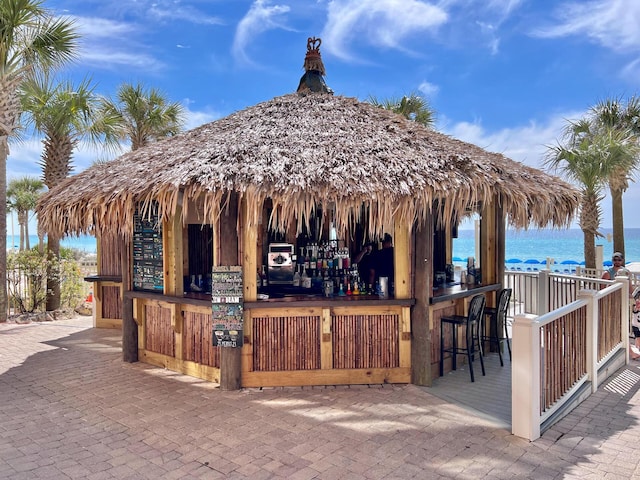 view of patio / terrace with a gazebo, a water view, and outdoor dry bar