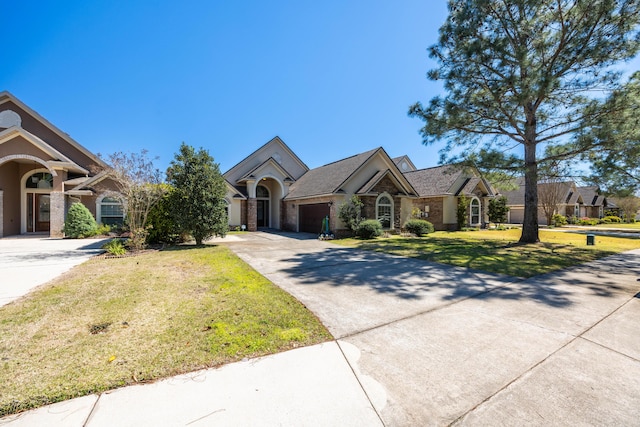 view of front of house with driveway, a front lawn, an attached garage, and brick siding