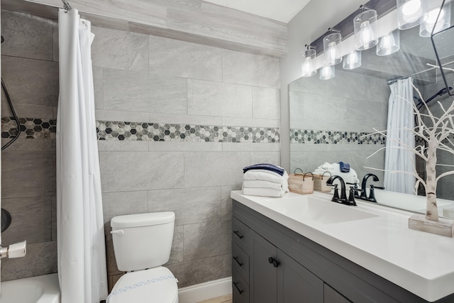 full bath with shower / bath combo, vanity, toilet, and tile walls