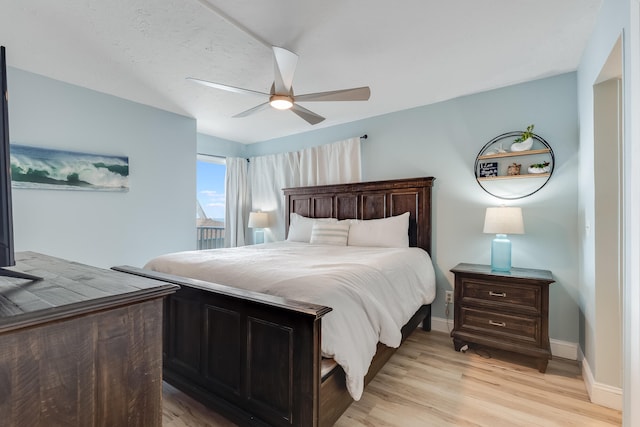 bedroom with light wood-style floors, ceiling fan, and baseboards