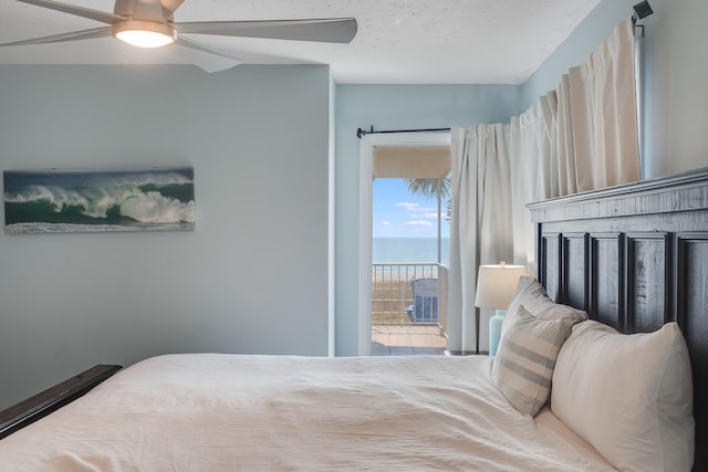 bedroom featuring ceiling fan, a water view, and access to exterior