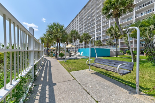 view of property's community featuring fence and a yard