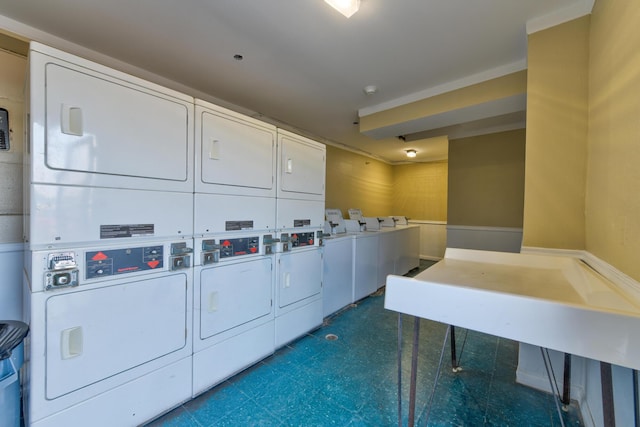 shared laundry area featuring stacked washer / dryer, washing machine and dryer, and dark floors