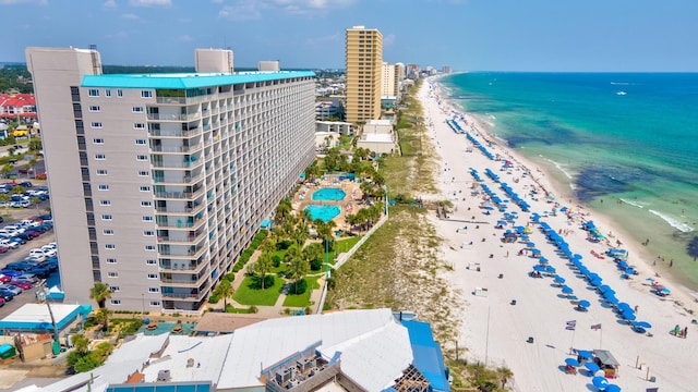 drone / aerial view featuring a water view, a view of the beach, and a city view