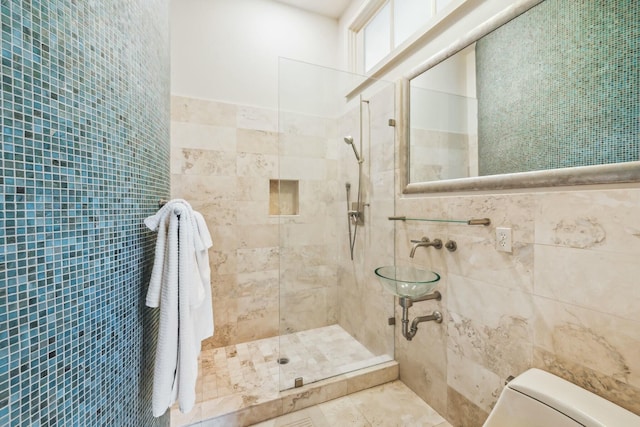 full bath with a shower stall, toilet, and tile walls