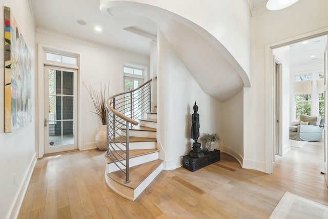 foyer entrance featuring light wood-type flooring, plenty of natural light, and baseboards