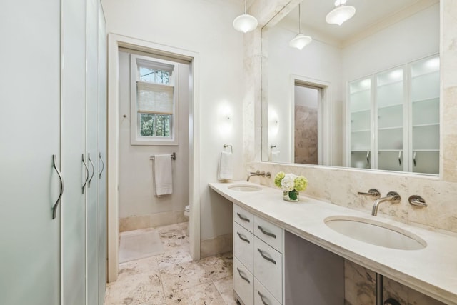 full bathroom featuring a sink, toilet, double vanity, and crown molding