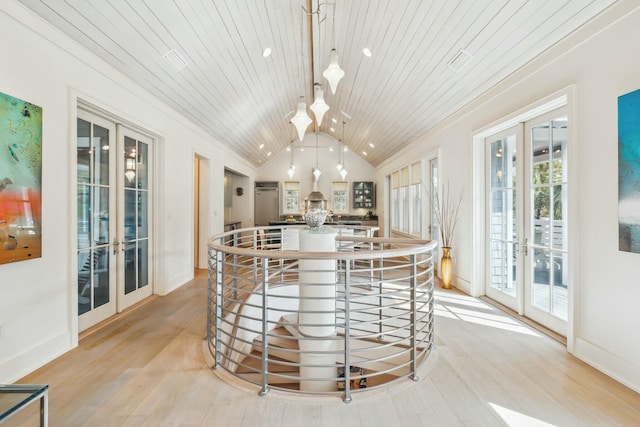 kitchen featuring lofted ceiling, light wood-style flooring, french doors, and a kitchen island