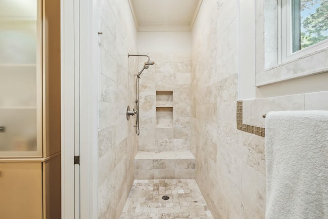 bathroom featuring crown molding and a tile shower