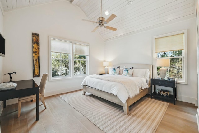 bedroom with multiple windows, lofted ceiling, and light wood-style floors