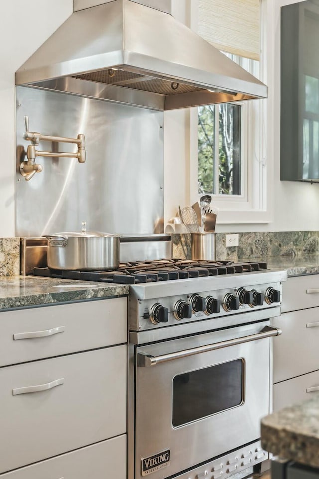 kitchen featuring stone counters, luxury stove, and island range hood