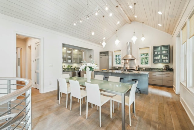 dining area with baseboards, high vaulted ceiling, rail lighting, wood ceiling, and light wood-style floors