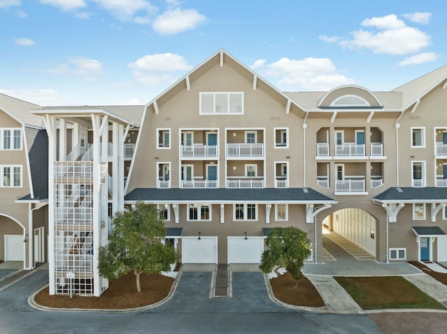 view of building exterior featuring stairway, an attached garage, and driveway