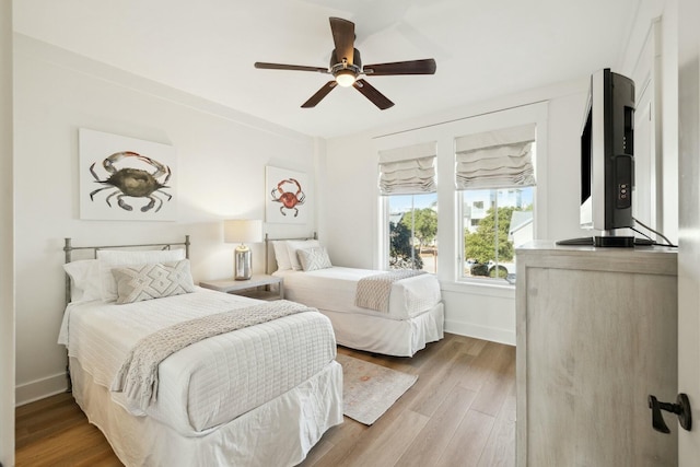 bedroom featuring a ceiling fan, wood finished floors, and baseboards