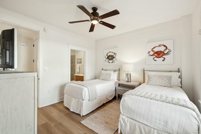 bedroom featuring a ceiling fan, ensuite bath, wood finished floors, and baseboards